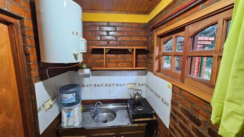 a small kitchen with a sink and a stove at Cabañas Rincon Santa Maria in Puerto Iguazú