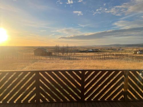 a view from the deck of a barn with the sunset in the background at Giltún Warm and Scenic Cottage In The Heart of South in Selfoss
