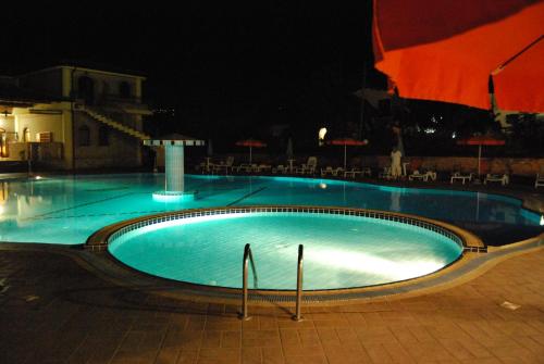 a large swimming pool at night with chairs and umbrellas at Hotel Gran Duca in Briatico