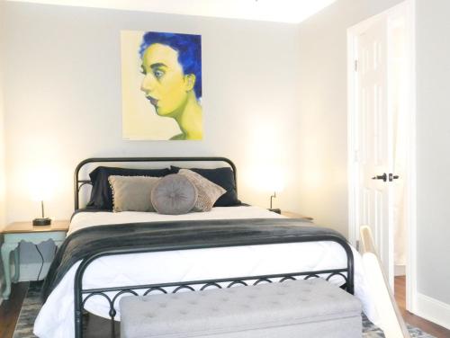 a bedroom with a bed with a painting on the wall at Charming St. Ann Studio in New Orleans