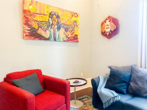 a living room with two chairs and a painting on the wall at Kerlerec Victorian Cottage - Steps to French Qtr. in New Orleans