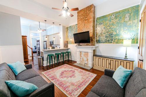 ein Wohnzimmer mit Couch und Kamin in der Unterkunft Ursulines Historic Creole Cottage- Steps to Qtr -E in New Orleans