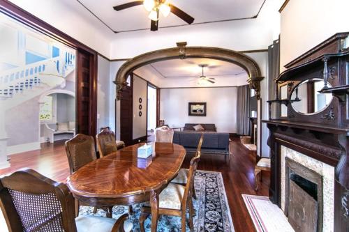 a living room with a wooden table and a fireplace at Claiborne Historic Mansion - 5 bed-3bath in New Orleans