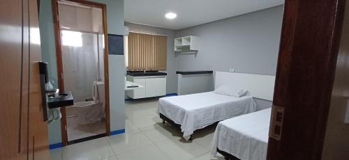 a small room with two beds and a kitchen at Brasil hotel in Canaã dos Carajás