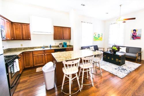 a kitchen with a counter and chairs in a room at Dumaine Cozy Home - 3 bed close to QTR in New Orleans