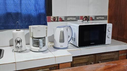 a kitchen counter with a microwave and appliances on it at Cabañas Rincon Santa Maria in Puerto Iguazú