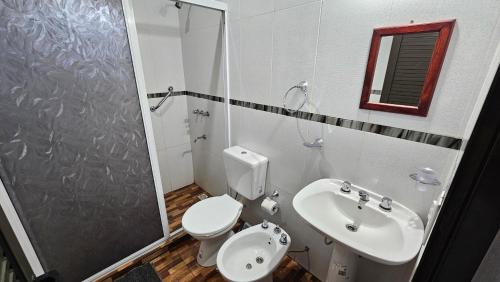a bathroom with a toilet and a sink and a shower at Cabañas Rincon Santa Maria in Puerto Iguazú