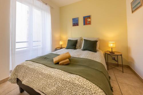 une chambre avec un lit avec deux lampes et une fenêtre dans l'établissement Joli cocon à 3 min à pied de la mer, à Nice