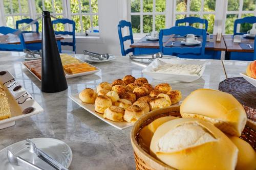 un tavolo ricoperto di piatti di pane e prodotti da forno di Hotel Fazenda Santanna ad Amparo