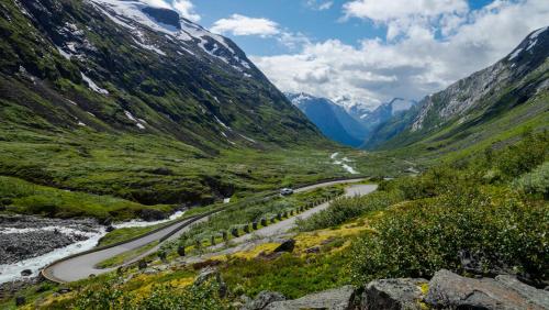a winding road through a mountain valley with a river at Hotel Videseter in Stryn