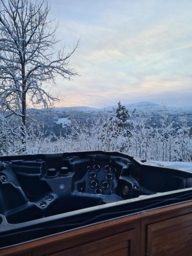 a snow covered bath tub with a view of the mountains at Panorama view along the fjord in Stryn in Blakset