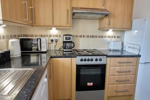 a kitchen with a stove and a microwave at 35A Coach Street in Skipton