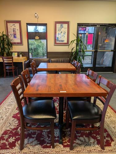 a dining room with wooden tables and chairs at Best Lynnwood Inn in Lynnwood
