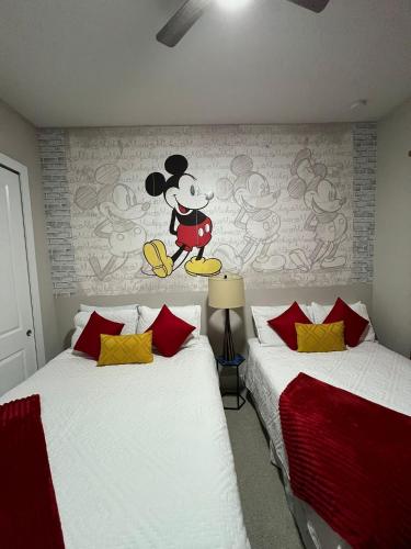 a bedroom with two beds with a mickey mouse mural on the wall at Disney here we go in Orlando