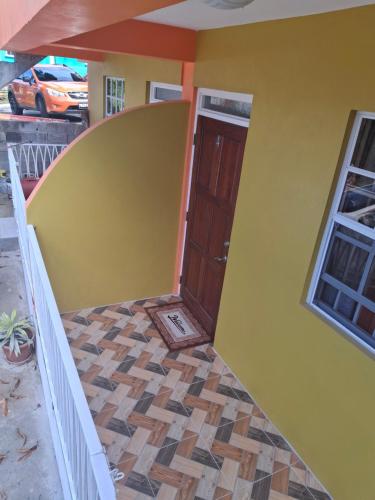 a front door of a house with a yellow wall at 8TN Cozy Apartments in Pointe Michel