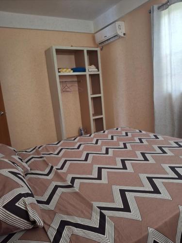 a bed with a brown and white comforter in a bedroom at 8TN Cozy Apartments in Pointe Michel