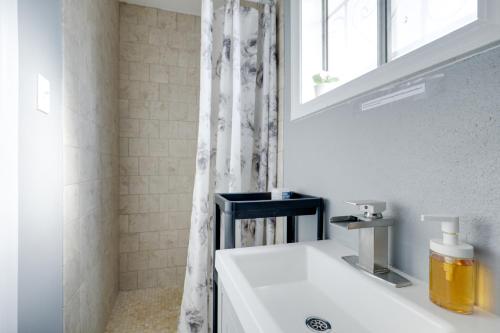 a white bathroom with a sink and a shower at North Las Vegas Hideaway with Grill Less Than 10 Mi to Strip in Las Vegas