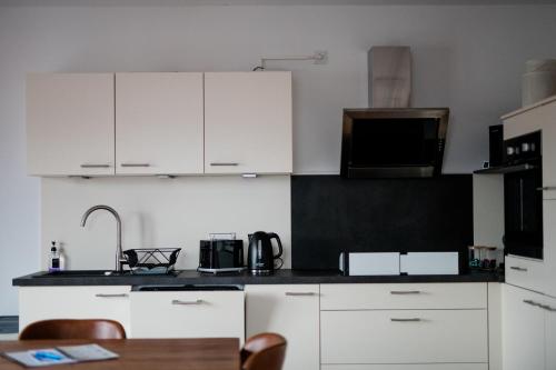 eine Küche mit weißen Schränken und einer schwarzen Arbeitsplatte in der Unterkunft Quiet Apartment - 74qm - 2 Bedrooms - 3 Beds in Limburg an der Lahn