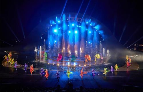 a fountain with people dancing in front of it at night at Sun Bay Hotel Phu Quoc in Phu Quoc