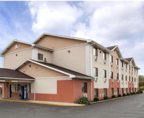 a large white building with a parking lot at Brookville Inn in Brookville