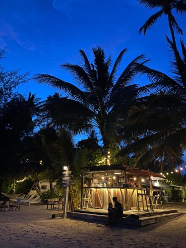 un ristorante su una spiaggia con palme di notte di Samui Caravans a Laem Sor