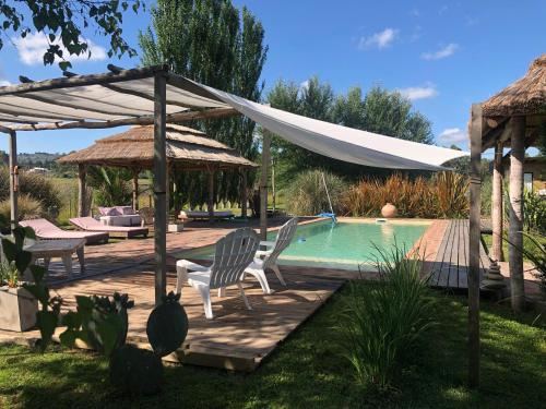 a patio with two chairs and a swimming pool at Kan Yu - Loft de Campo in Tandil