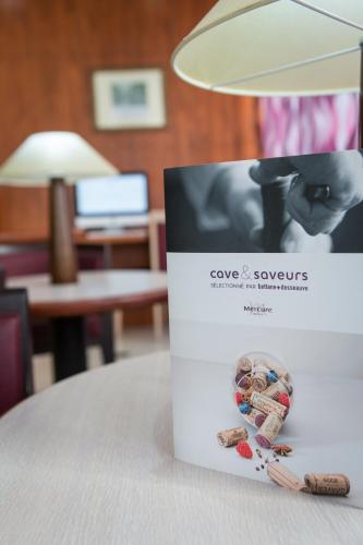 a box sitting on top of a table with a lamp at Mercure Béziers in Béziers