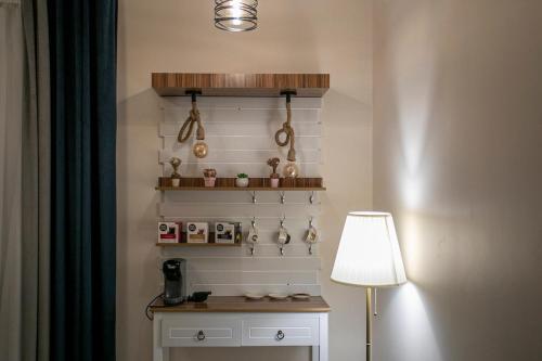 a room with a table with a lamp and a shelf at Hayatt Ula Suite - 104 in AlUla