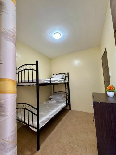 a bedroom with two bunk beds in a room at Bacolod Bungalow House - Max 6 Pax in Bacolod