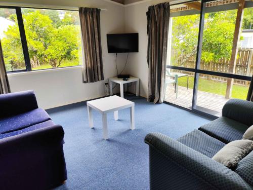 a living room with two couches and a tv at Motel Villa Del Rio in Whangarei