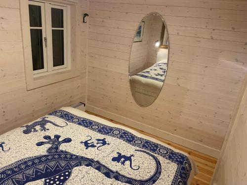 a small room with a bed and a mirror at Lilla Grellbo in Grebbestad