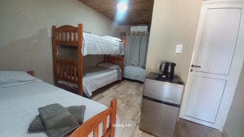 a bedroom with a bunk bed and a refrigerator at Alojamiento Pytu'u Pora in Colonia Carlos Pellegrini