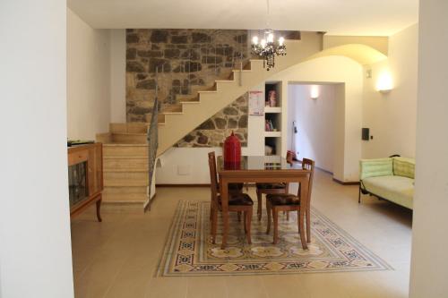 ein Wohnzimmer mit einem Tisch und einer Treppe in der Unterkunft B&B Danonna in Ittiri