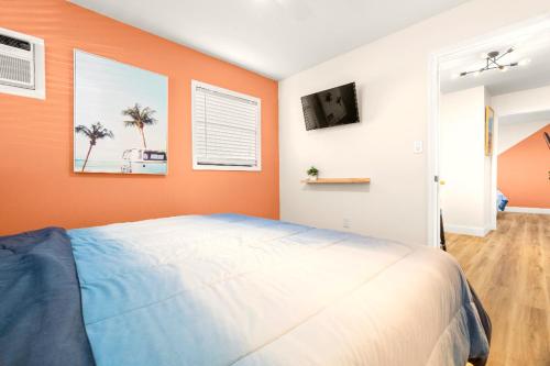 a bedroom with an orange wall and a bed at Boutique Beach Retreat in St Pete Beach
