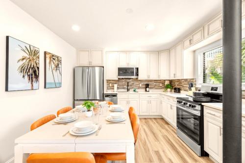 a white kitchen with a white table and chairs at Boutique Beach Retreat in St Pete Beach