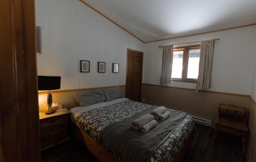 a bedroom with a bed with towels on it at Glazonki Cozy Chalet in Sainte-Agathe-des-Monts