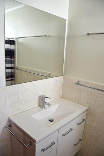 a bathroom with a sink and a mirror at Traveller's Palms 7 - Bring your own linen. in South West Rocks
