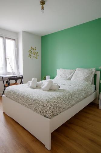 - un lit blanc dans une chambre dotée d'un mur vert dans l'établissement Appartement Cosy douillet - Proche du Tram - Gare & Circuit 24H, au Mans