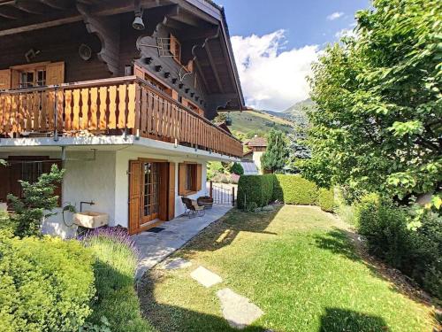 a house with a balcony on top of a yard at Chalet Lion d'Or in Bagnes