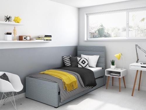 a bedroom with a bed and a desk and a window at BBV Properties in Belmont