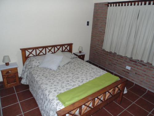 a bedroom with a bed and a brick wall at Cabañas los amigos Pino in Potrero de Garay