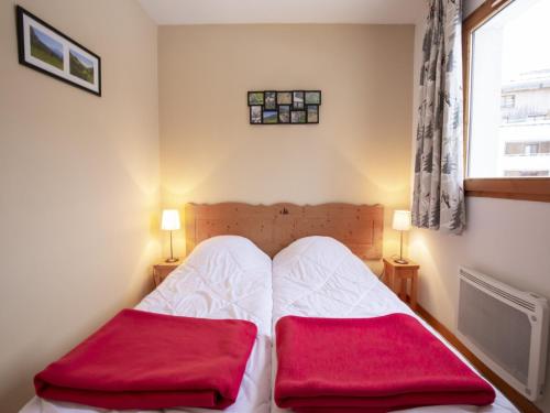 une chambre avec un lit avec deux oreillers rouges dessus dans l'établissement Apartment in Termignon near Gondola, à Val Cenis