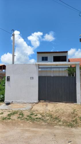 a white building with a gate with the number on it at Casa Brisa do Mar in Tamandaré