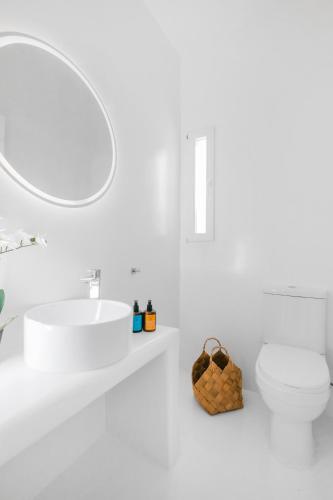 a white bathroom with a sink and a toilet at Island Riviera Mykonos Villa in Agios Sostis Mykonos