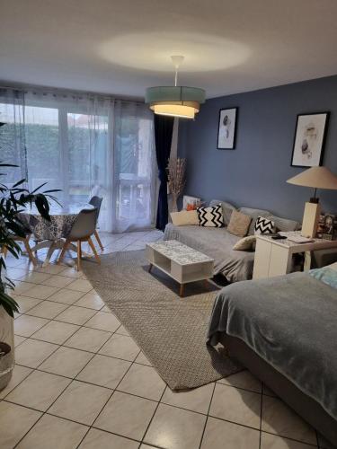 a living room with a couch and a table at Appartement de 51 m2 avec jardin de 51 m2, parking privé in Achères
