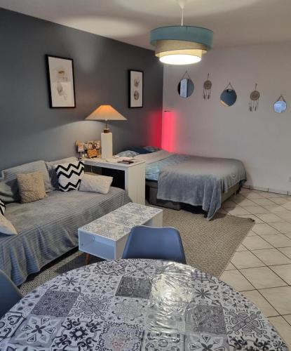 a living room with two beds and a couch at Appartement de 51 m2 avec jardin de 51 m2, parking privé in Achères