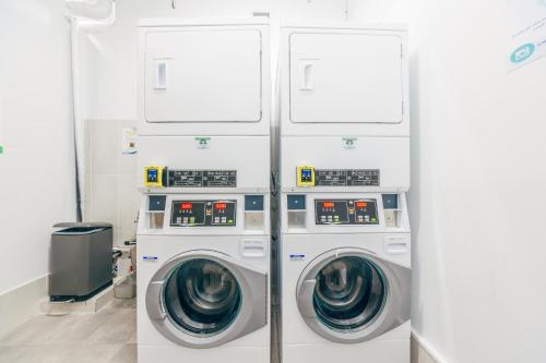 two washing machines in a laundry room with two machines at Maze Backpackers - Gold Coast in Gold Coast
