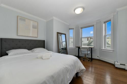 a bedroom with a bed and a desk and windows at The Princeton Boston Luxurious Apartment - New! - Near Downtown Boston, Airport in Boston