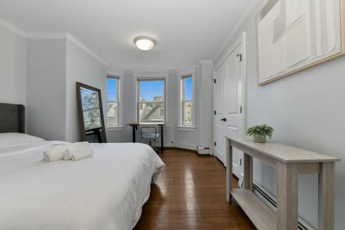 a bedroom with two beds and a table and windows at The Princeton Boston Luxurious Apartment - New! - Near Downtown Boston, Airport in Boston