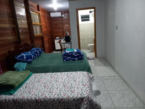 two beds sitting in a room with a hallway at Pousada Germânia Paraíso do Sul in Paraíso do Sul